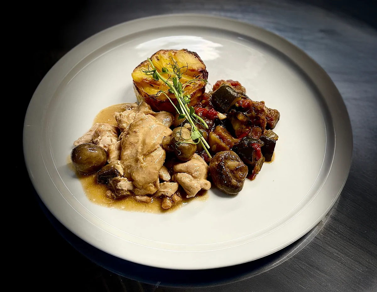 Une assiette de volaille aux champignons accompagnée de sa garniture.